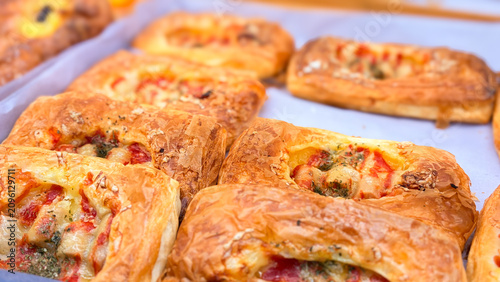 Vászonkép Delicious golden savory pastries with cheese, tomato, and herb toppings, fresh f