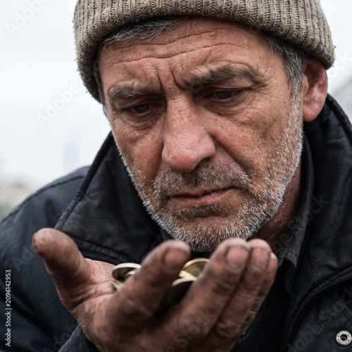 Elderly Man Contemplating Coins in Hand with a Thoughtful Expression