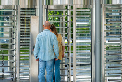 employees, workers accessing secure corporate facility automated turnstile gate, Woman entering daily routine, scanning badge, Modern security checkpoint, workplace safety, controlled entry procedures