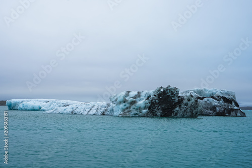 Картината върху платно Large iceberg floating in calm ocean waters under overcast sky,Jokulsarlon,Icela