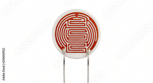 Macro of a bare photoresistor LDR cell showing the serpentine cadmium sulfide track on a ceramic base. Isolated on white background.