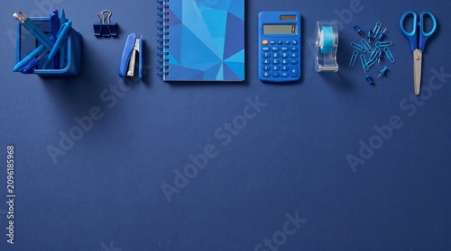 Blue office supplies on blue background desk stationery