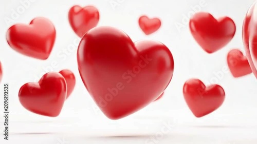Multiple vibrant red 3D hearts floating and scattered against a soft white background, symbolizing love and romance.