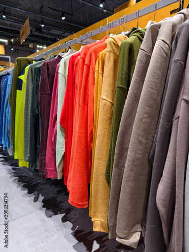 Assorted hooded sweatshirts hanging in a sports shop offer comfortable and versatile clothing for everyday use