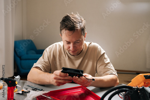 Pensive young adult technician male repairing and installing computer liquid cooling system, showcasing pc building, technical support. Concept of computer hardware maintenance and upgrade.