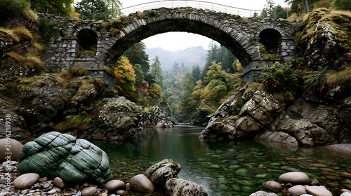 Old stone bridge over a calm river in a misty forest