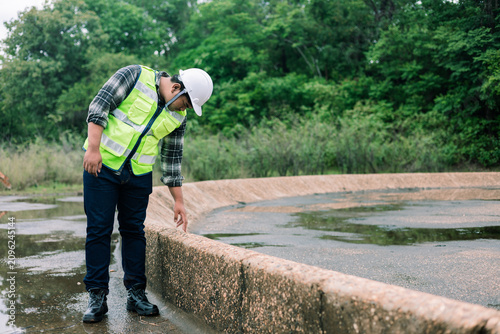 Environmental engineer inspecting wastewater treatment pond.