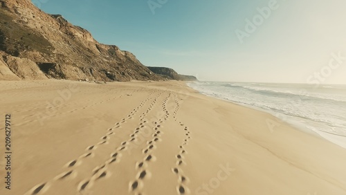 Golden sand beach and blue ocean coastline aerial drone shot