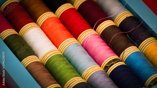 Colorful Sewing Thread Spools on a Vibrant Red Background