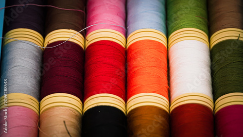 Colorful Sewing Thread Spools on a Vibrant Red Background