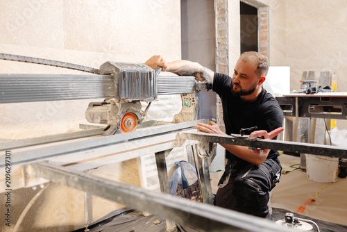 Construction worker cutting tile with tile saw during renovation works
