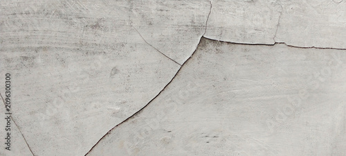 Concrete surface with deep cracks and a smooth texture resulting from weathering.