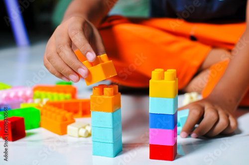 A young child plays with building blocks to learn.