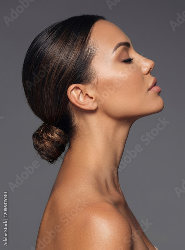 Obraz na płótnie Elegant side profile portrait of a beautiful woman with her dark hair styled in