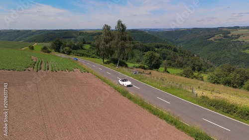Convertible Cars Driving on Scenic Winding Road in Luxembourg