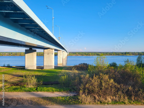 A large road bridge over a blue river, with the sky and banks in the background.