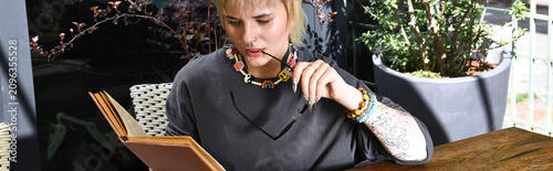 фотографія Cozy moments in a cafe with a stylish young lgbtq woman immersed in a book