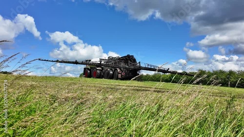 Modern slurry tanker with trailing hose applicator on a meadow in action. The high capacity slurry tanker demonstrates modern farming technology for fertilization and soil management on open grassland