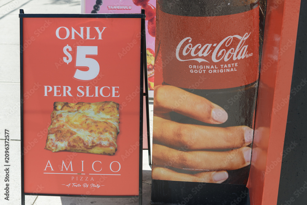 Obraz premium a-frame sidewalk sign outside Amico Pizza with ad for Coca-Cola located at 252 Queen St W, Toronto