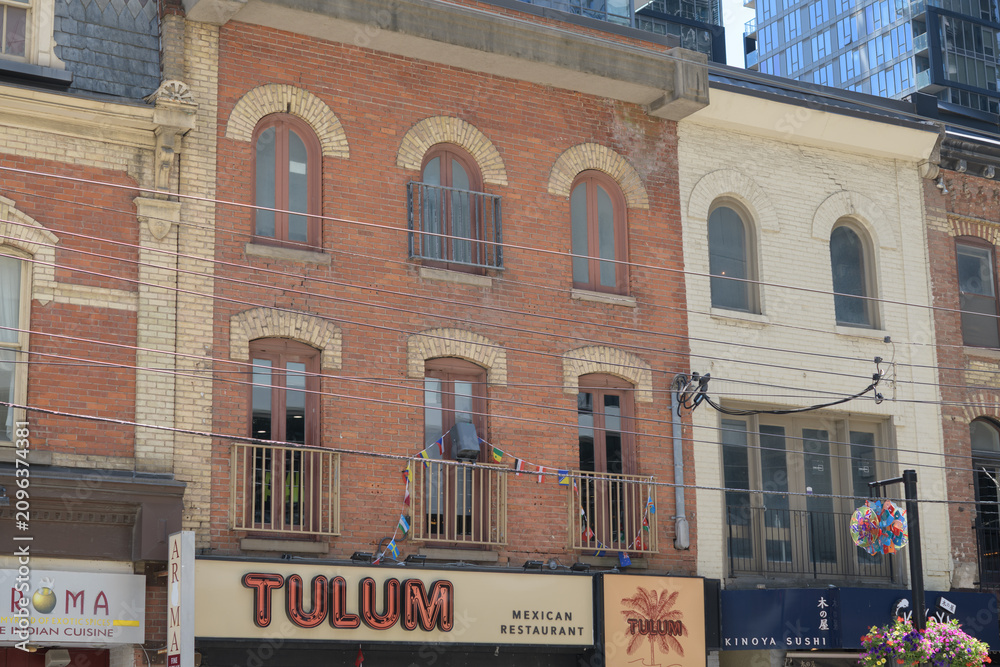 Obraz premium historic building facade and sign of Tulum Mexican Restaurant located at 291 King St W, Toronto