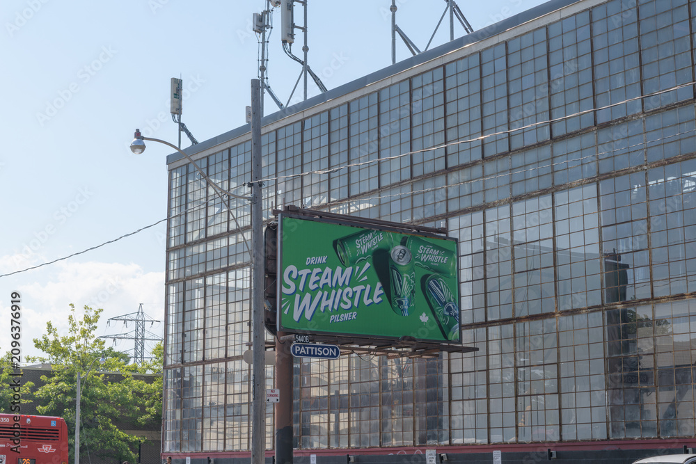 Obraz premium roadside billboard featuring advertising for Steam Whistle brewery, right by the old Hamilton Gear and Machine Company factory, 950 Dupont St at Dovercourt, Toronto