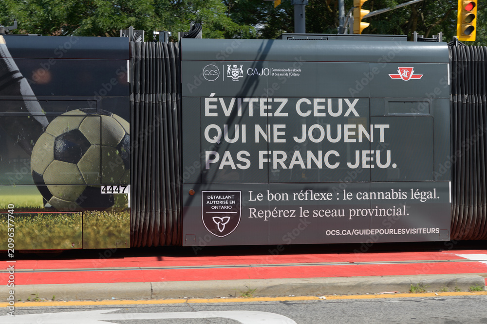 Obraz premium Ontario Cannabis Store (OCS) trolley wrap with message in French re steer clear of illicit unregulated dispensaries, in Toronto