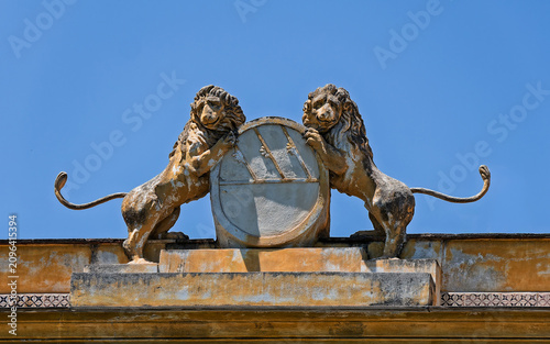 Tableau sur toile Detailed view of a traditional stone coat of arms with lions on a historic roofline balustrade in Palermo, Italy