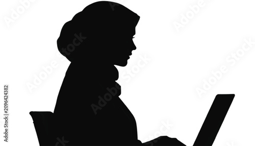Professional student wearing a hijab sits at a desk while typing on her laptop to complete academic research assignments in a quiet and focused environment intended for study.