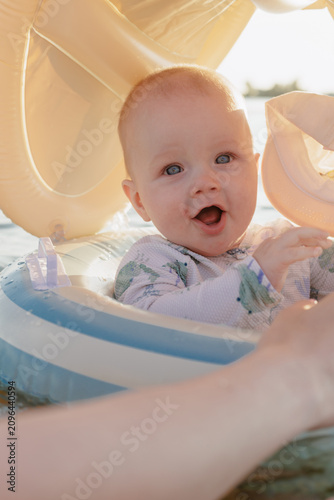 фотографія Joyful baby with blue eyes in a swim ring on a sunny day