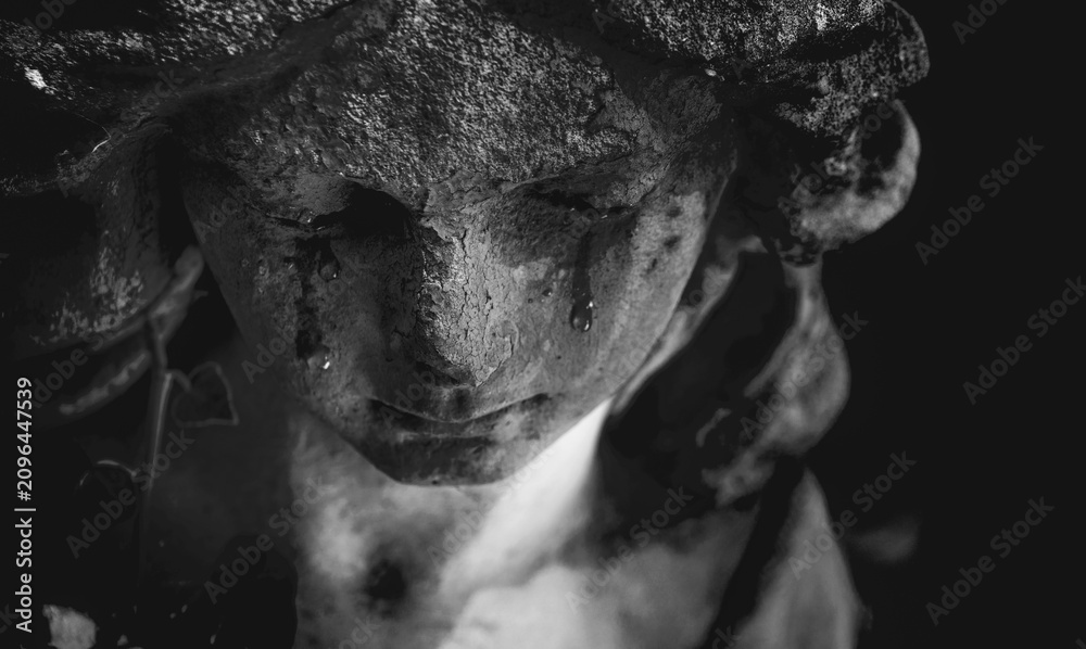 Obraz premium Black and white statue of a weeping angel with tear-stained face. A symbolic portrait expressing that angels mourn alongside humanity, representing compassion