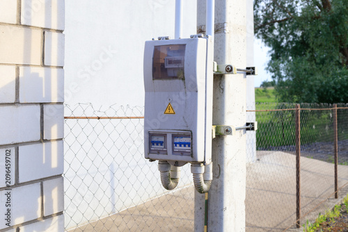 Quadro su tela Outdoor electric meter box with high voltage warning sign on concrete pole, elec