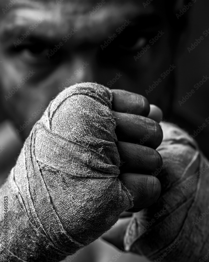 Fototapeta premium Black and White Boxing Fighter Training: Focus, Power, and Determination - Close-Up Portrait of Strong Male Athlete