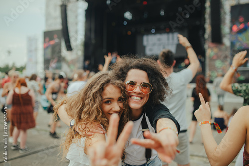 Фотография Two young women friends walking at summer festival.