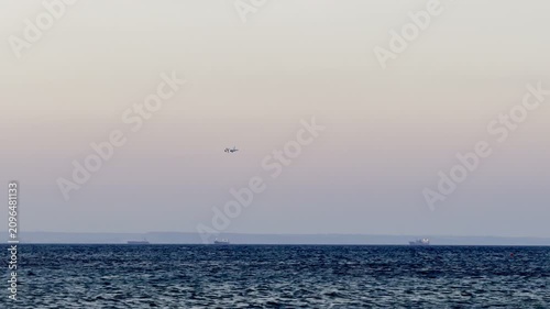 A plane is landing while flying low over the sea. Cyprus Island, tourist boats, Mediterranean Sea.