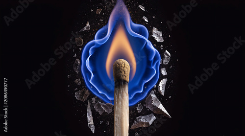 Ignited match with blue flame and broken glass on black background, dramatic macro advertising concept