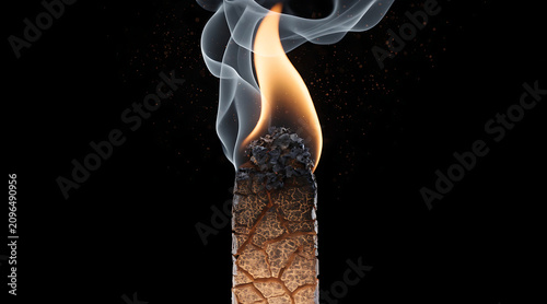 Burning candle with smoke on black background, close up macro of wax flame and charred wick