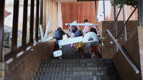 Students climbing stairs toward landing, bouncing packs initiating overlays of stars and 3D shapes