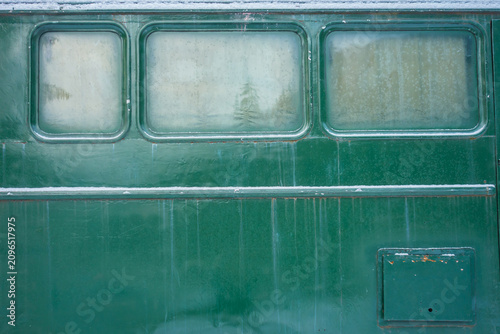 Aged green train car exterior with frosted windows, displaying weathered textures.