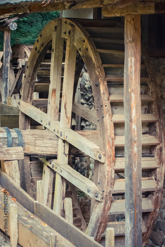 Fotografie Rustic wooden water wheel turning amidst a serene countryside setting