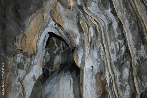 Foto Deep natural niche and layered limestone formations on the cave wall inside Kova