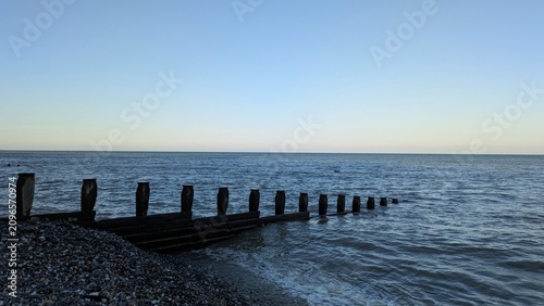 Obraz na płótnie Old wooden breakwaters and a calm sea on the English Channel coast