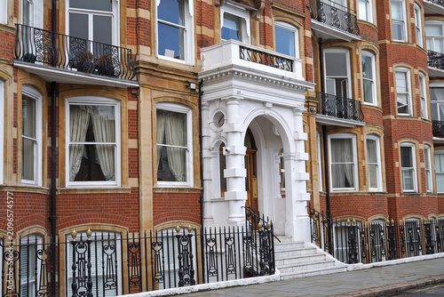 White portico entrance to red brick apartment building in London