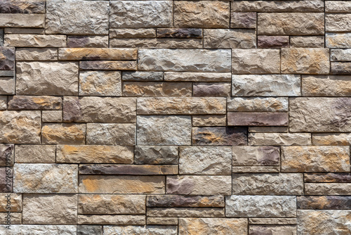 Full frame abstract texture background of a of a ledgerstone style brick wall, with natural stone in different shapes and sizes