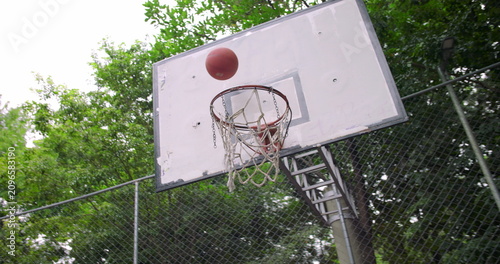 Foto Man of African descent runs toward basketball hoop and jumps to score during int