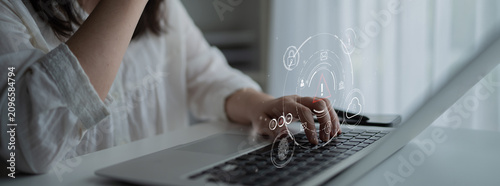 Картината върху платно A Young Woman Engaged in Innovative Work at Home, Using Laptop with Graphic Illustrations of Technology and Creativity in Modern Workspace