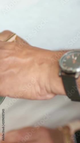 Vertical video: Using chopsticks by green bowl, right hand picking at table sharing meal