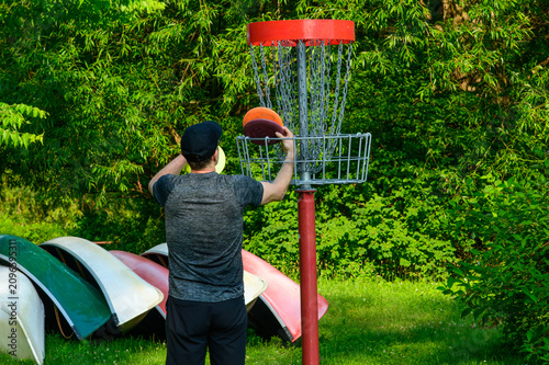 Man Collecting Discs From Chain Basket