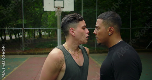 Cuadro en lienzo Two Hispanic men face off in intense standoff during street basketball game, hea