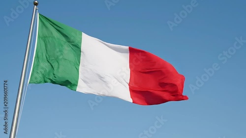 Italian flag waving against a clear blue sky