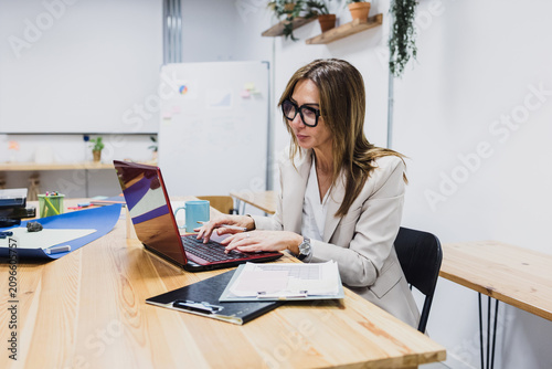 latina business senior women working and using laptop at office. Hispanic mature female at workplace